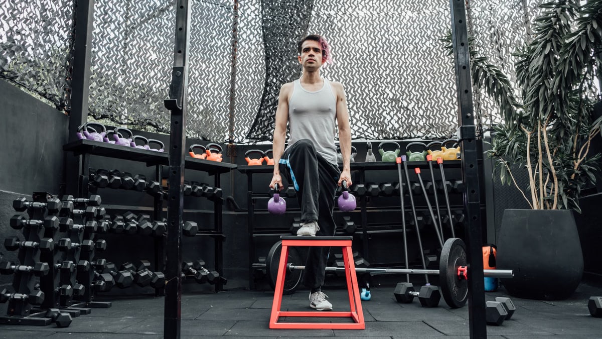 Adult male performing kettlebell exercises in a modern Mexico City gym.